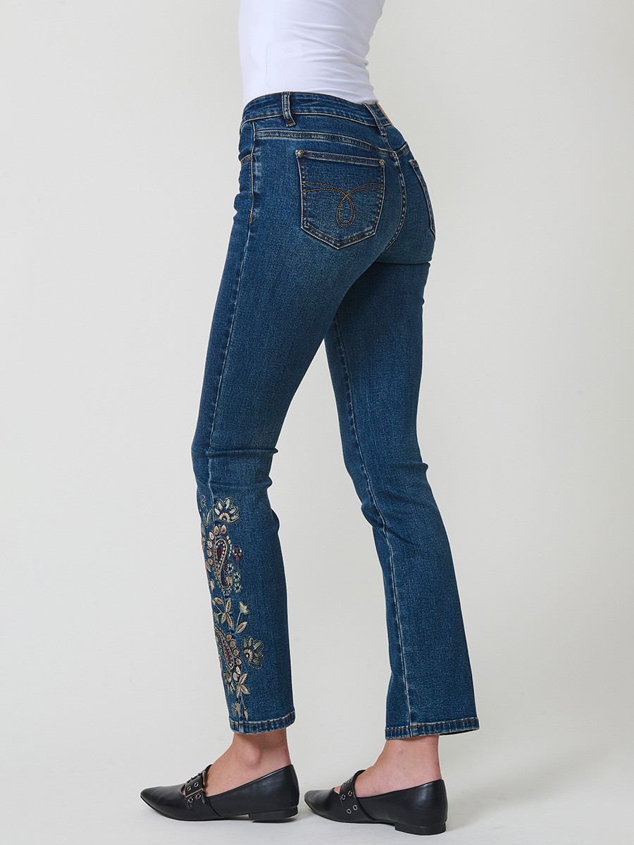 Jeans slim azul muy oscuro elásticos, tiro medio, cinco bolsillos, cierre metálico y bordado con brillos en bolsillo y bajo.