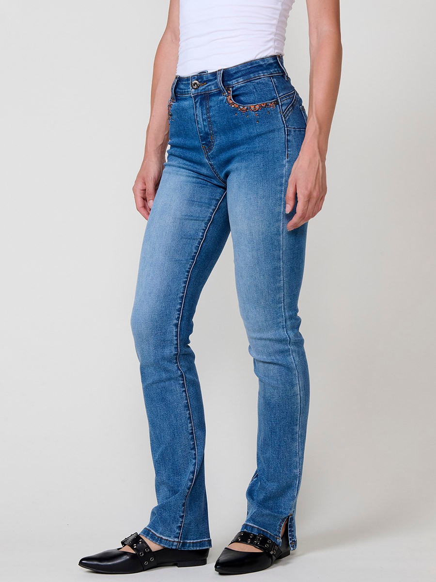 Jeans regular push up azul oscuro de mujer, tiro medio, cinco bolsillos, bordado con brillos y aberturas laterales en el bajo.