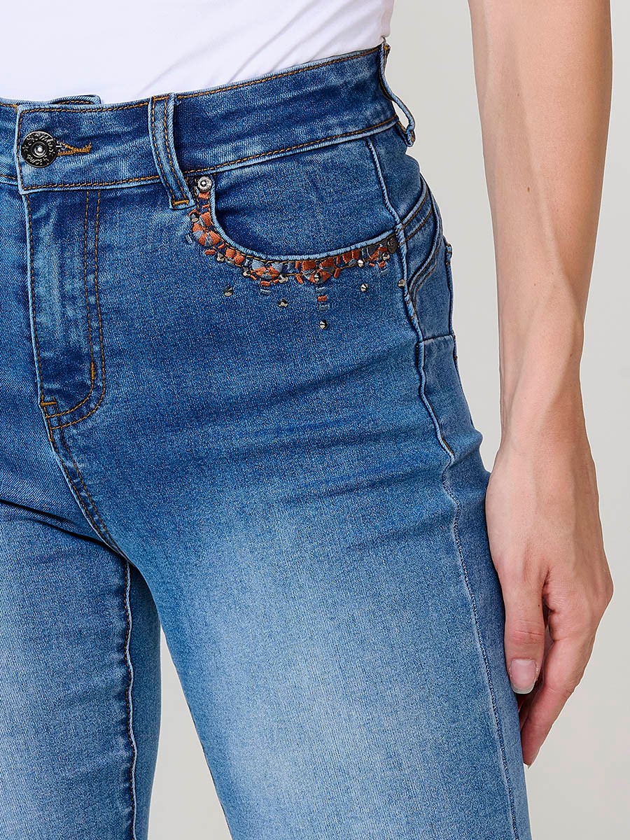 Jeans regular push up azul oscuro de mujer, tiro medio, cinco bolsillos, bordado con brillos y aberturas laterales en el bajo.