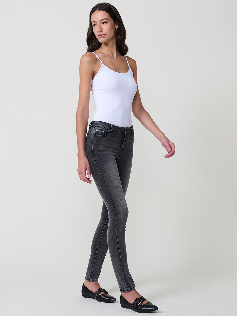 Jeans slim negro de mujer en denim elástico, tiro medio, cinco bolsillos, cierre metálico y placa Koröshi en el frontal.