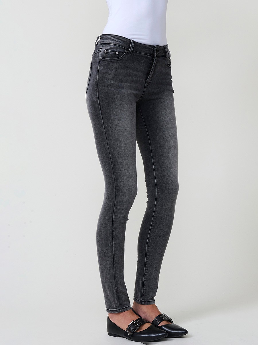 Jeans slim negro de mujer en denim elástico, tiro medio, cinco bolsillos, cierre metálico y placa Koröshi en el frontal.