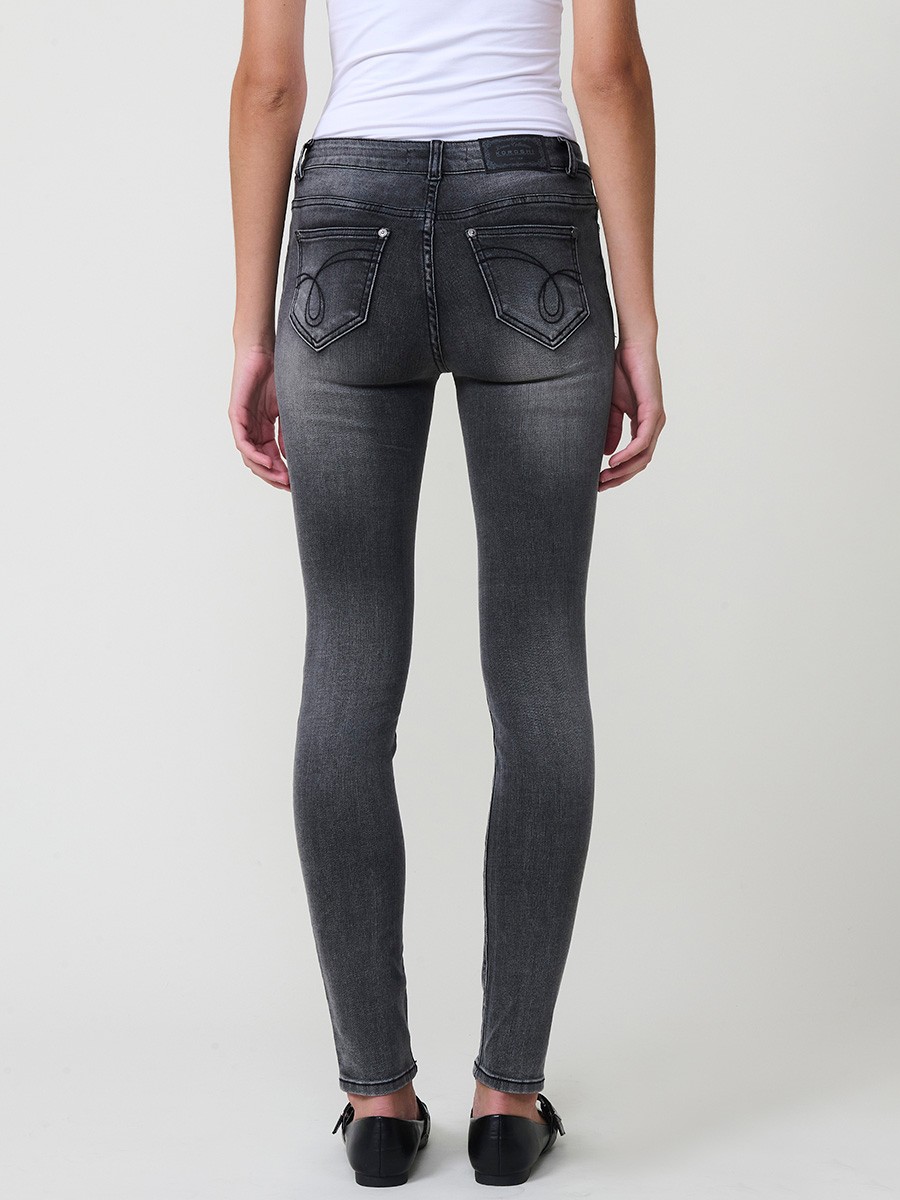 Jeans slim negro de mujer en denim elástico, tiro medio, cinco bolsillos, cierre metálico y placa Koröshi en el frontal.