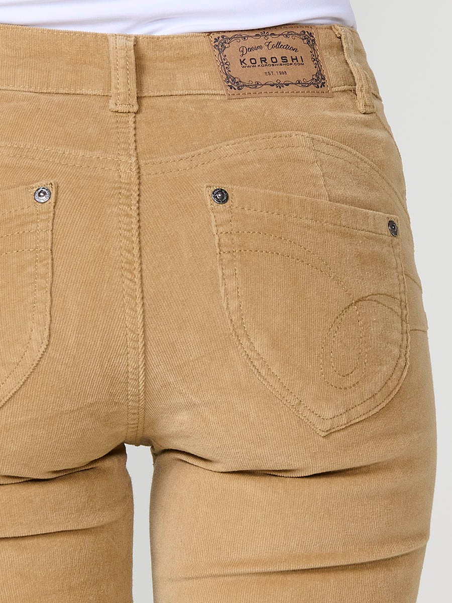 Pantalón de micropana elástica para mujer en color ocre. Corte regular con efecto doble push up, tiro medio y cinco bolsillos.