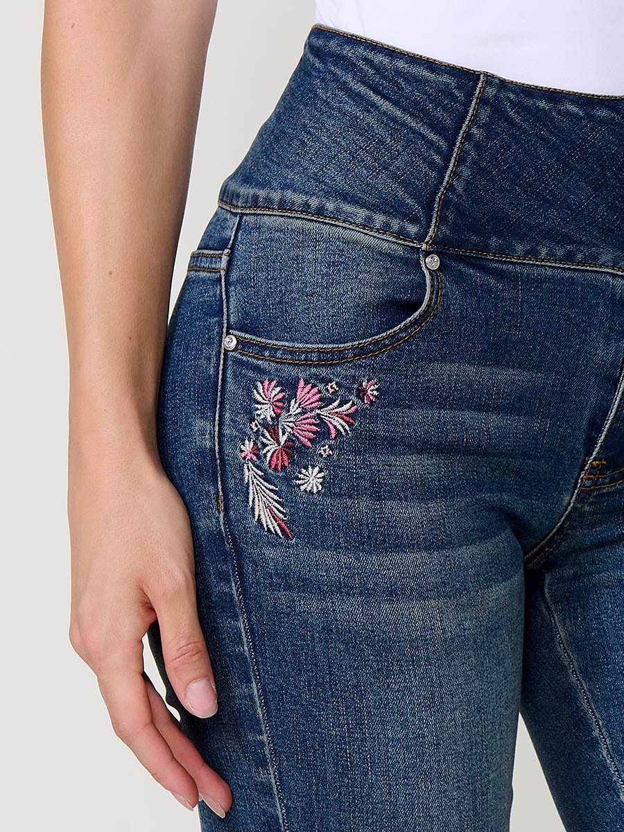 Jeans corset slim de mujer en denim azul oscuro elástico, tiro alto, cinco bolsillos y cierre con tres botones metálicos.