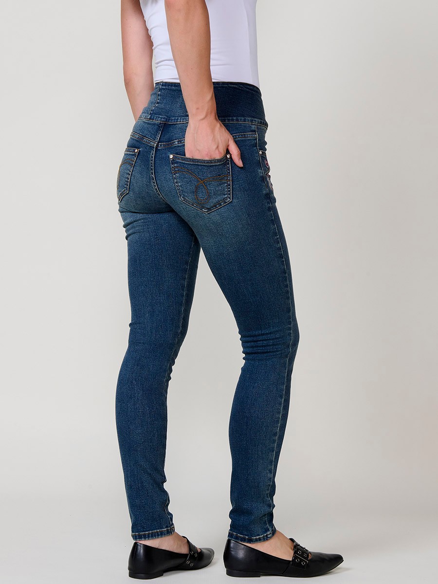 Jeans corset slim de mujer en denim azul oscuro elástico, tiro alto, cinco bolsillos y cierre con tres botones metálicos.