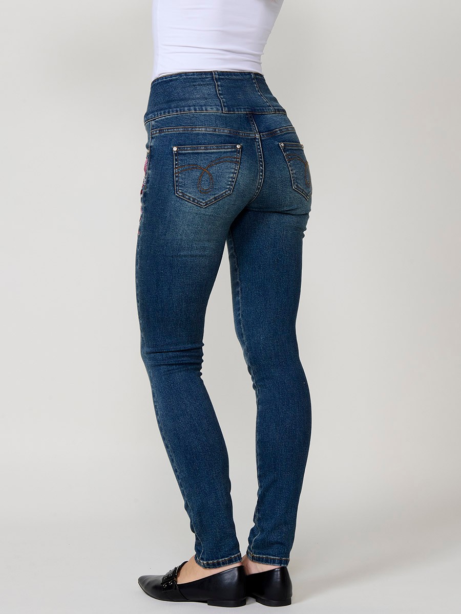 Jeans corset slim de mujer en denim azul oscuro elástico, tiro alto, cinco bolsillos y cierre con tres botones metálicos.