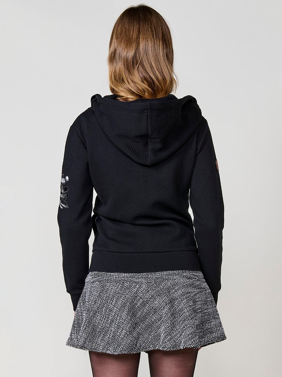 Sudadera abierta de mujer con capucha, tejido doble cara, interior polar, cremallera diagonal y bordado floral en el frontal y manga.