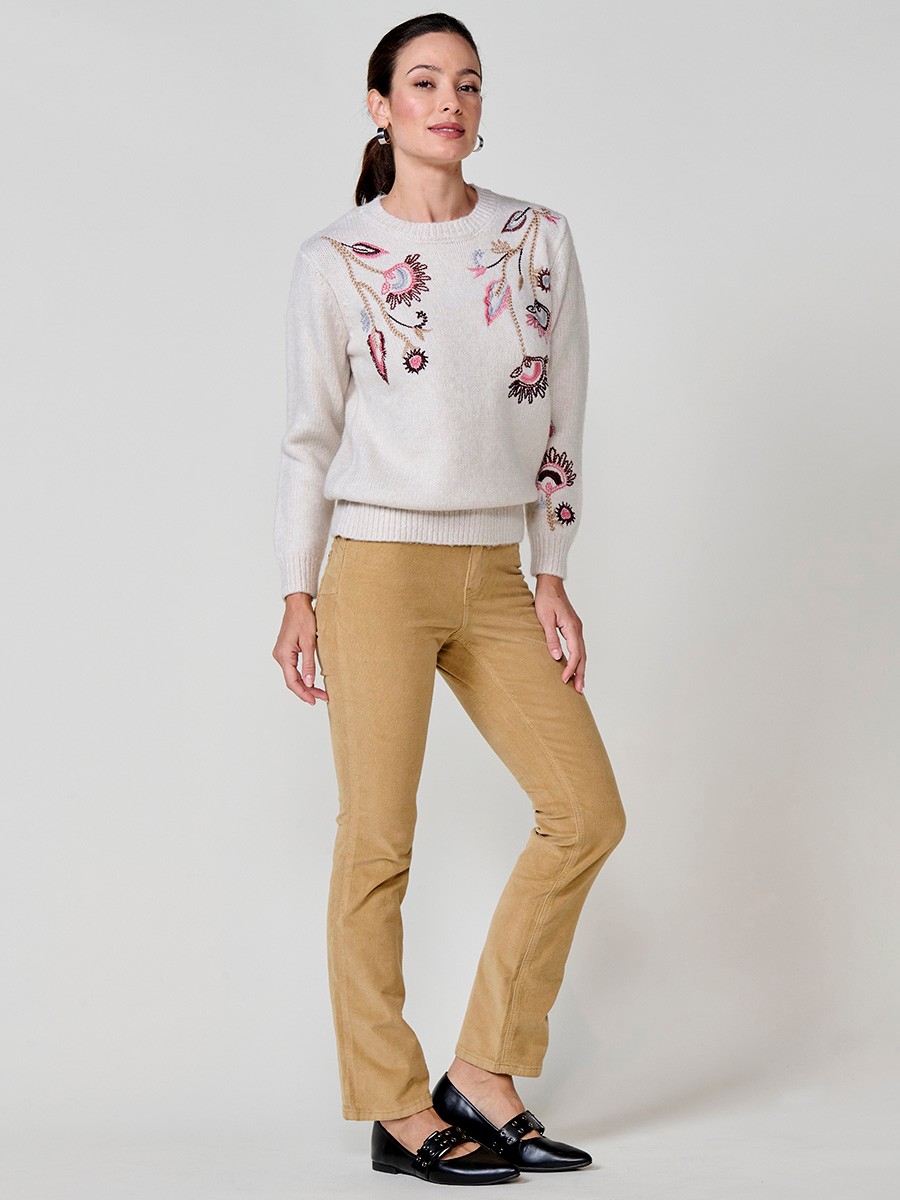 Women’s ivory knit sweater with long sleeves, round neckline, floral embroidery on front and sleeve, Koröshi metal logo plate at hem.