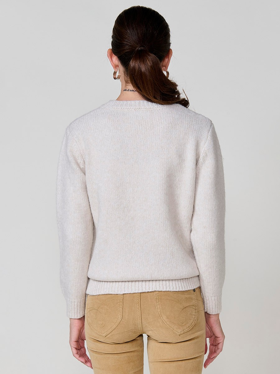Women’s ivory knit sweater with long sleeves, round neckline, floral embroidery on front and sleeve, Koröshi metal logo plate at hem.