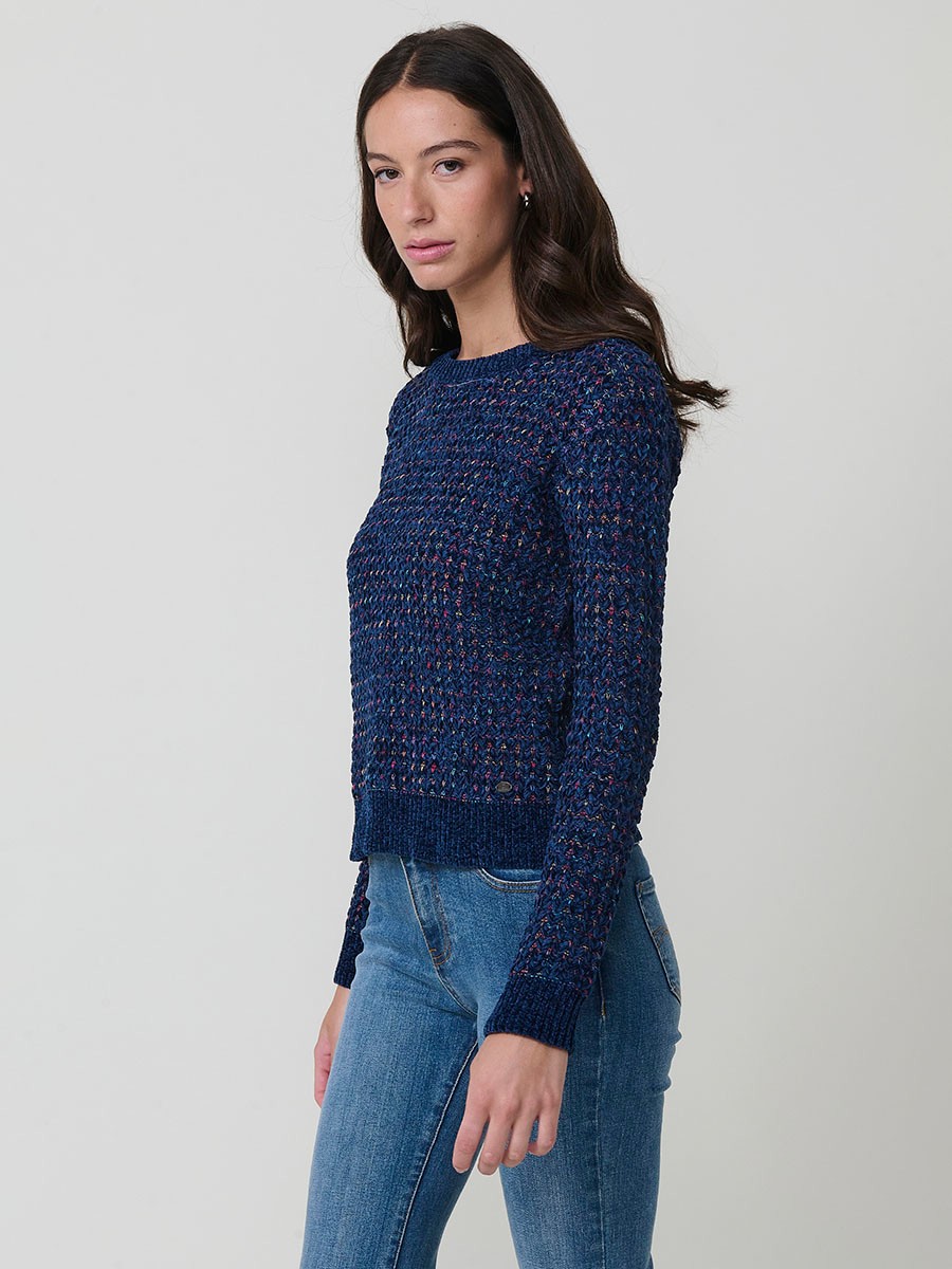 Jersey de punto para mujer, con escote redondo, manga larga y diseño de corazones multicolor. Detalle de placa metálica con logo Koröshi