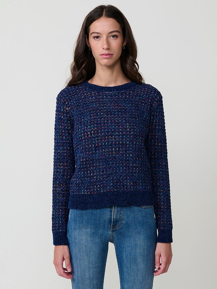 Jersey de punto para mujer, con escote redondo, manga larga y diseño de corazones multicolor. Detalle de placa metálica con logo Koröshi
