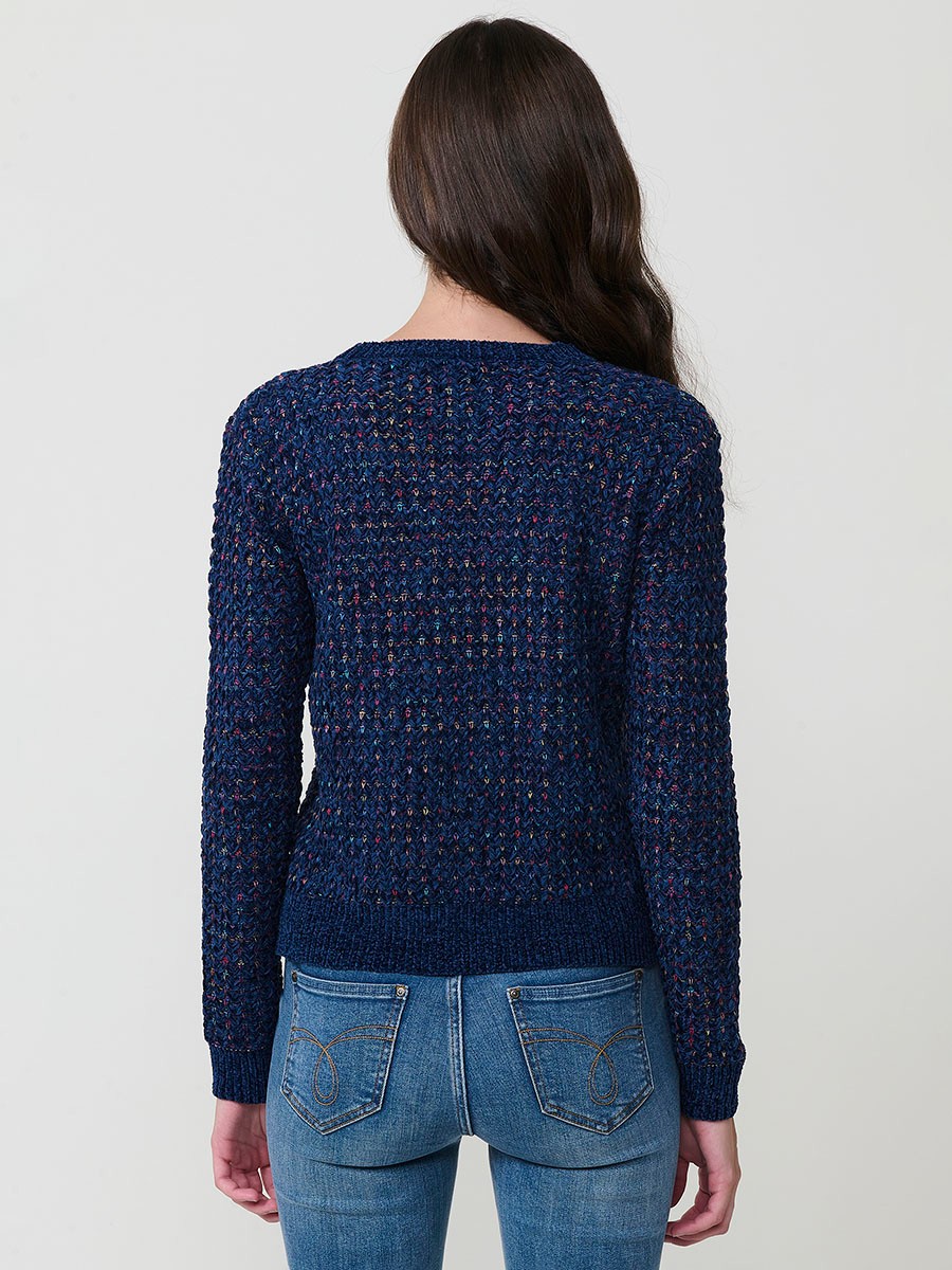 Jersey de punto para mujer, con escote redondo, manga larga y diseño de corazones multicolor. Detalle de placa metálica con logo Koröshi