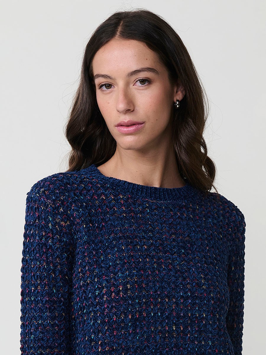 Jersey de punto para mujer, con escote redondo, manga larga y diseño de corazones multicolor. Detalle de placa metálica con logo Koröshi