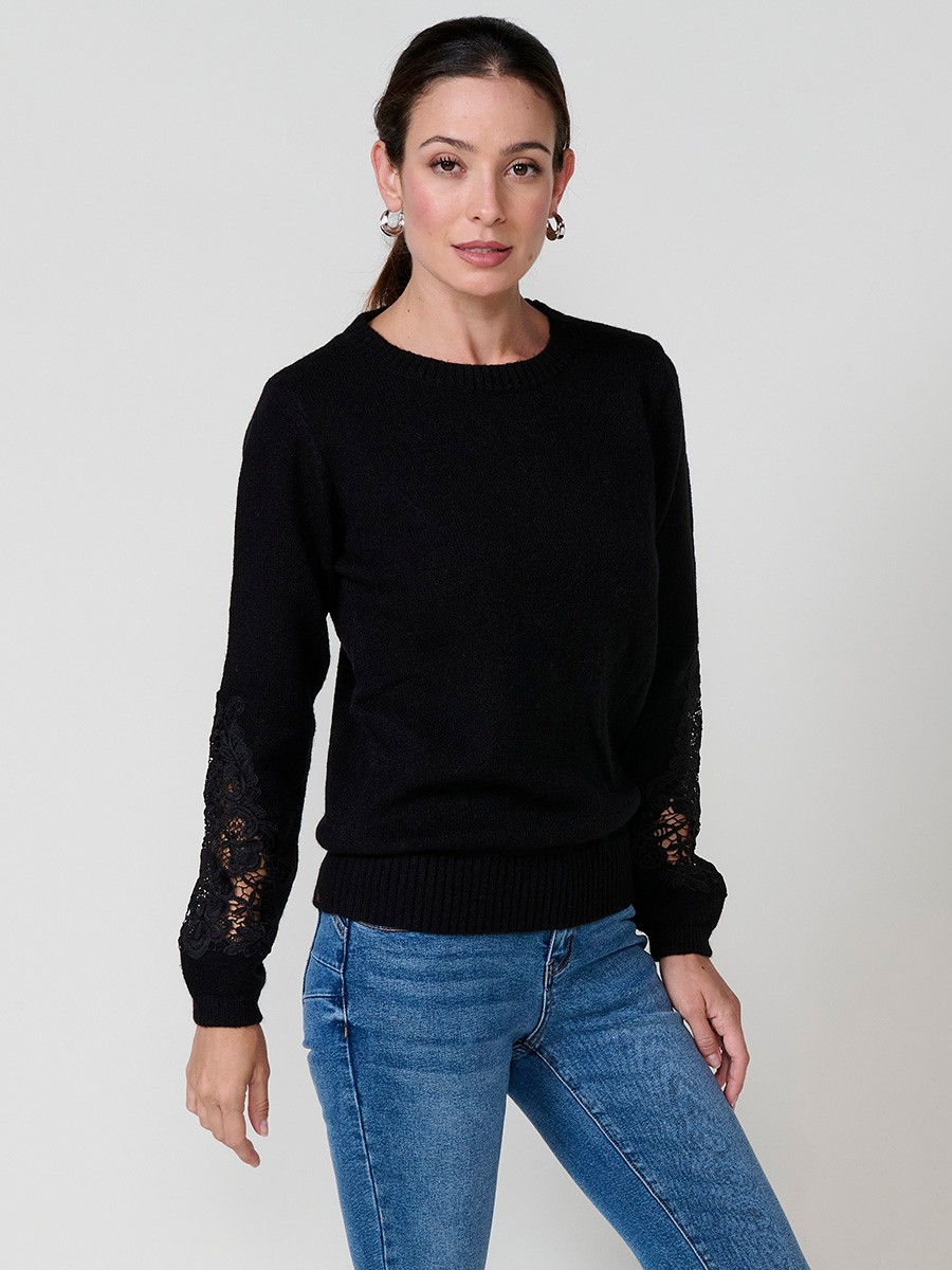 Jersey de mujer negro de punto liso, manga larga abullonada, encaje floral calado en mangas y placa metálica Koröshi en el bajo.