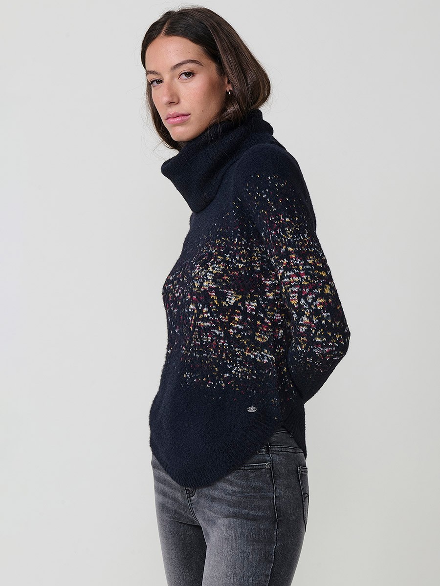 Jersey de punto para mujer, cuello alto, manga larga, bajo redondeado y dibujo jacquard. Tacto suave. Detalle de placa metálica con logo Koröshi.