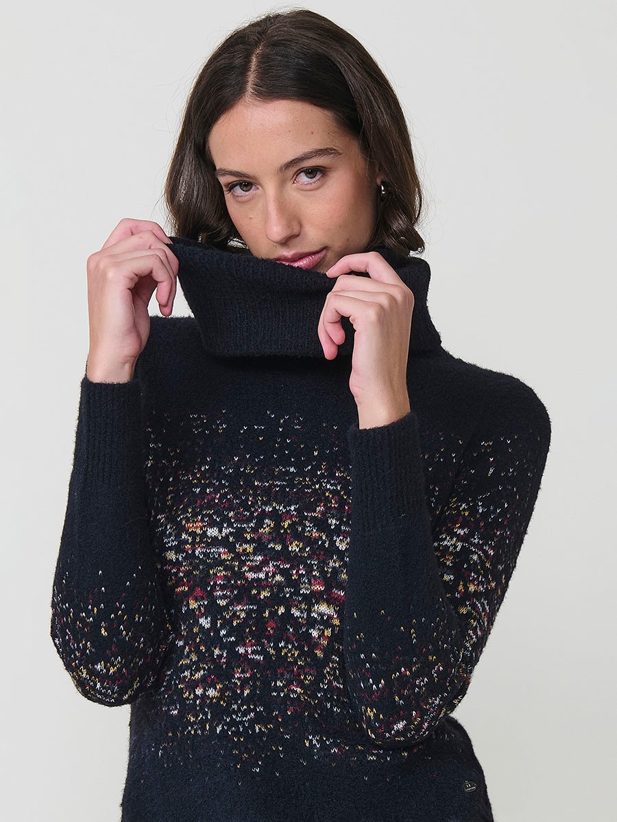 Jersey de punto para mujer, cuello alto, manga larga, bajo redondeado y dibujo jacquard. Tacto suave. Detalle de placa metálica con logo Koröshi.