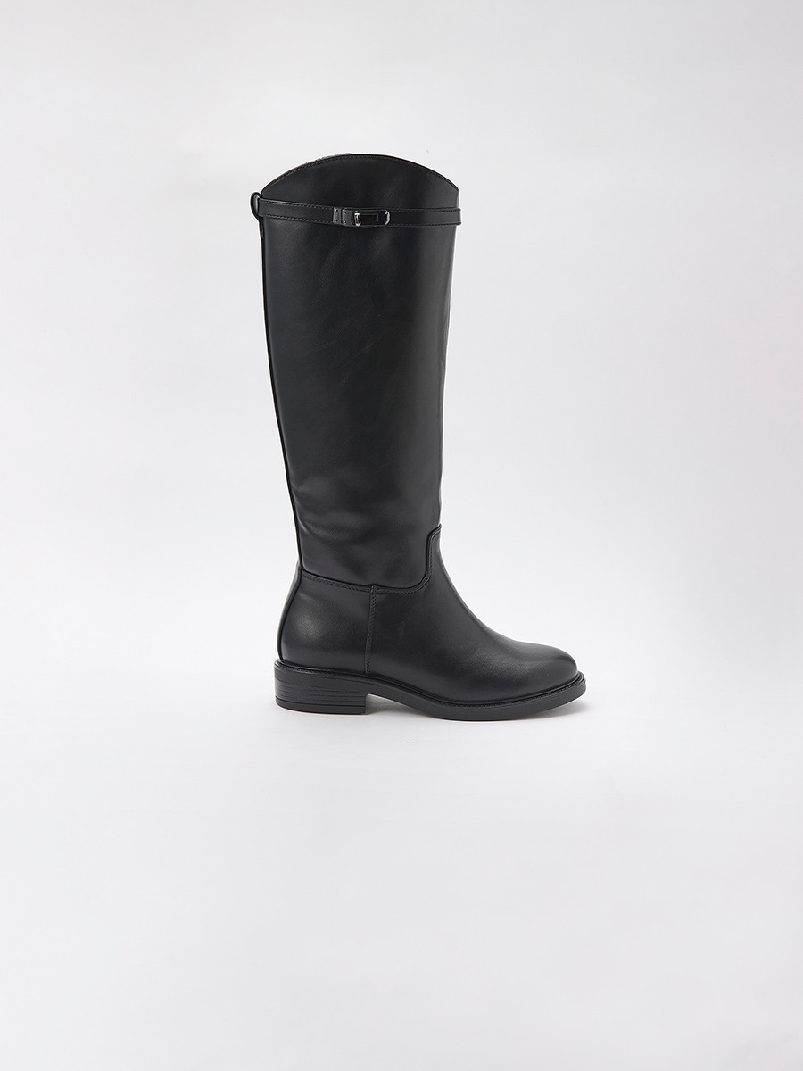 Bota plana de caña alta en efecto piel negra, estilo montar, con hebilla decorativa, cremallera interior y forro efecto pelo.