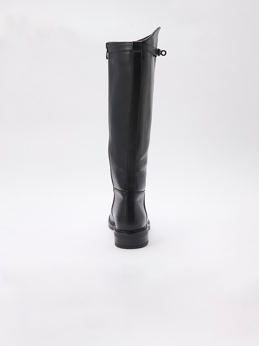 Bota plana de caña alta en efecto piel negra, estilo montar, con hebilla decorativa, cremallera interior y forro efecto pelo.
