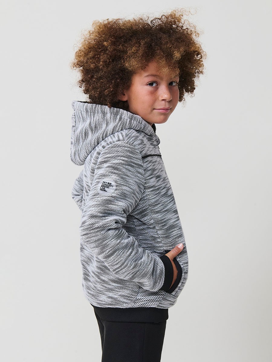 Veste en maille spéciale pour garçon, coloris noir et écru, avec capuche doublée effet fourrure et intérieur matelassé.