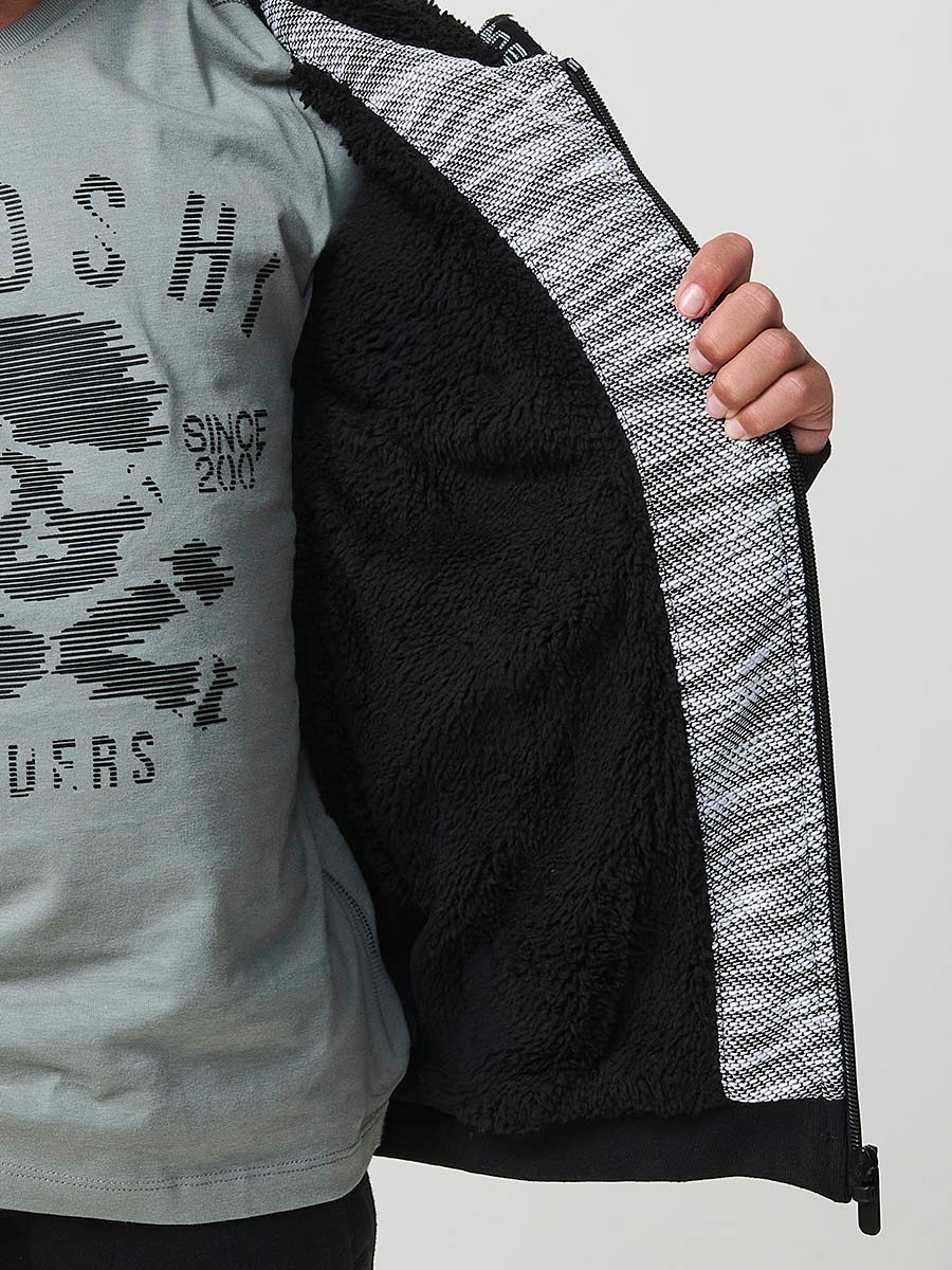 Veste en maille spéciale pour garçon, coloris noir et écru, avec capuche doublée effet fourrure et intérieur matelassé.