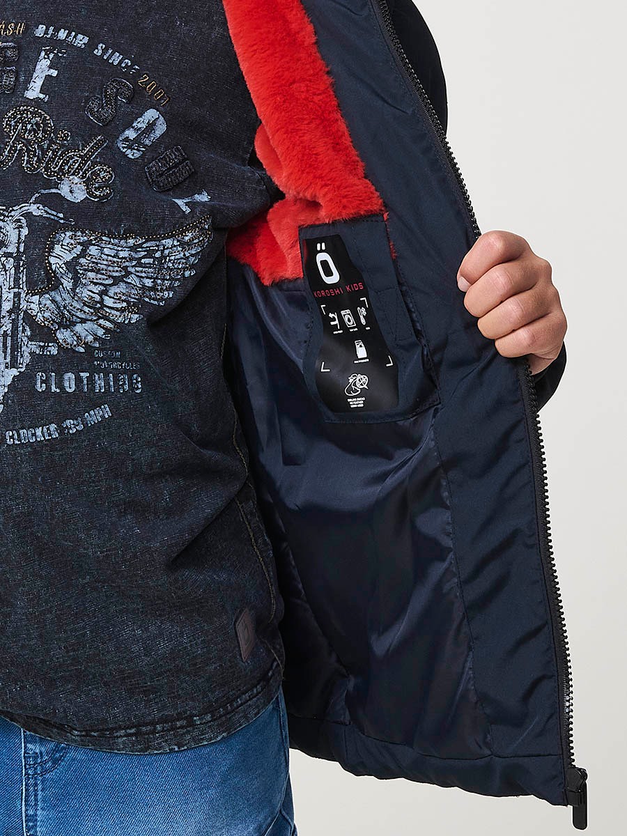 Blouson matelassé garçon en coloris navy avec capuche effet fourrure et fermeture zippée. Chaud et confortable.