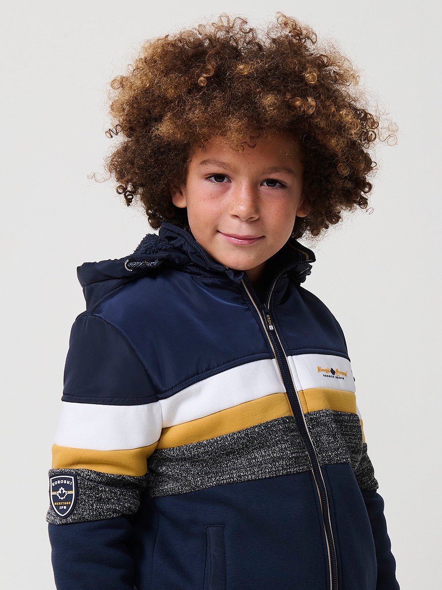 Veste garçon navy en molleton de coton et polyester, doublée et avec capuche amovible.