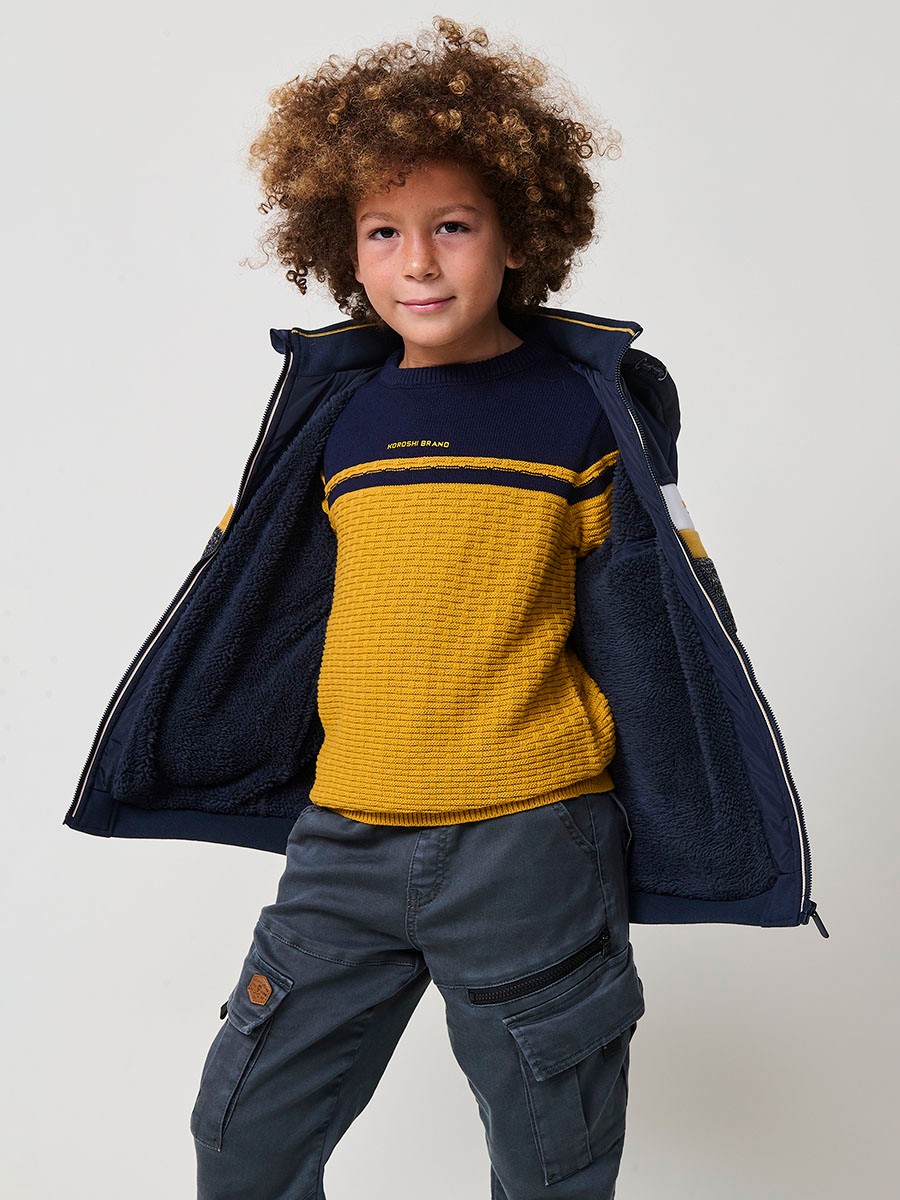 Veste garçon navy en molleton de coton et polyester, doublée et avec capuche amovible.