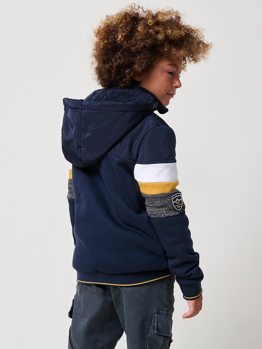 Veste garçon navy en molleton de coton et polyester, doublée et avec capuche amovible.