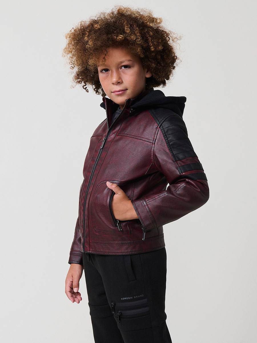 Cazadora de niño estilo motorista en color vino y negro efecto envejecido. Confeccionada en 100% poliéster con cierre de cremallera.