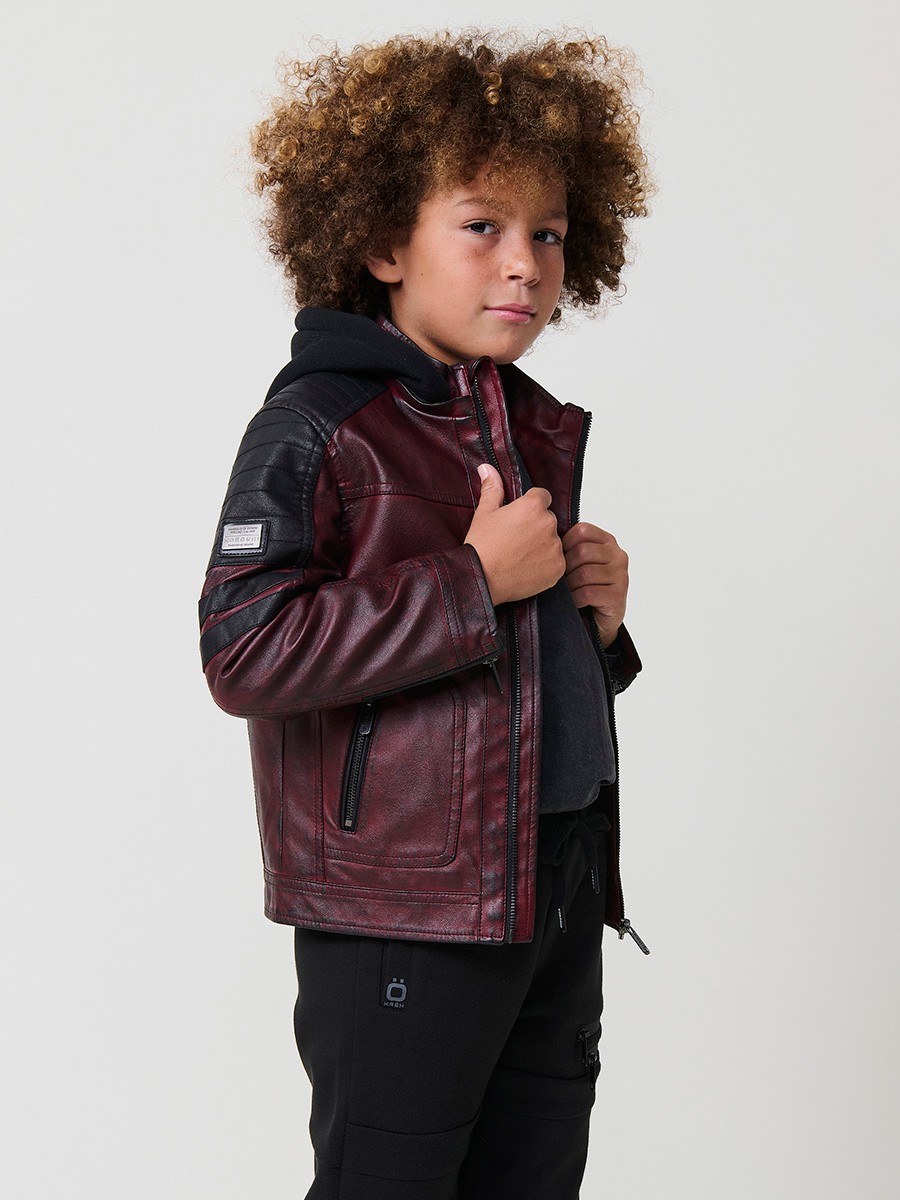 Cazadora de niño estilo motorista en color vino y negro efecto envejecido. Confeccionada en 100% poliéster con cierre de cremallera.