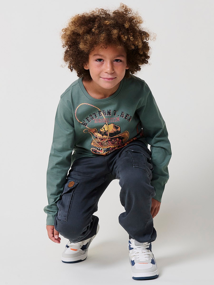 Camiseta de niño en color kaki, cuello redondo de canalé y estampado de dinosaurio. Detalle logo Koröshi boy en efecto piel.