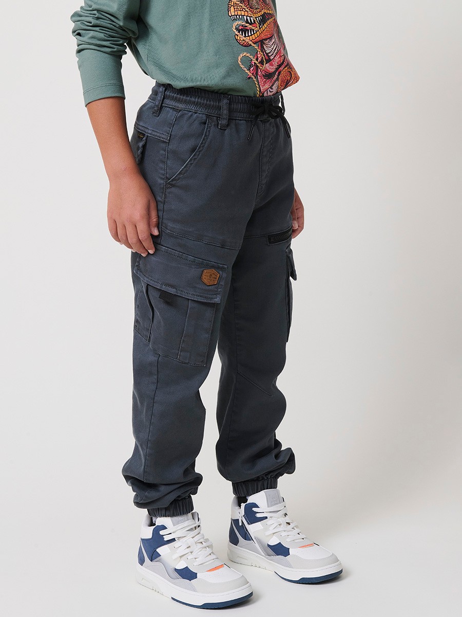 Pantalón jogger de niño en knit denim elástico color verde con bolsillos cargo. 100% algodón, cómodo y moderno.