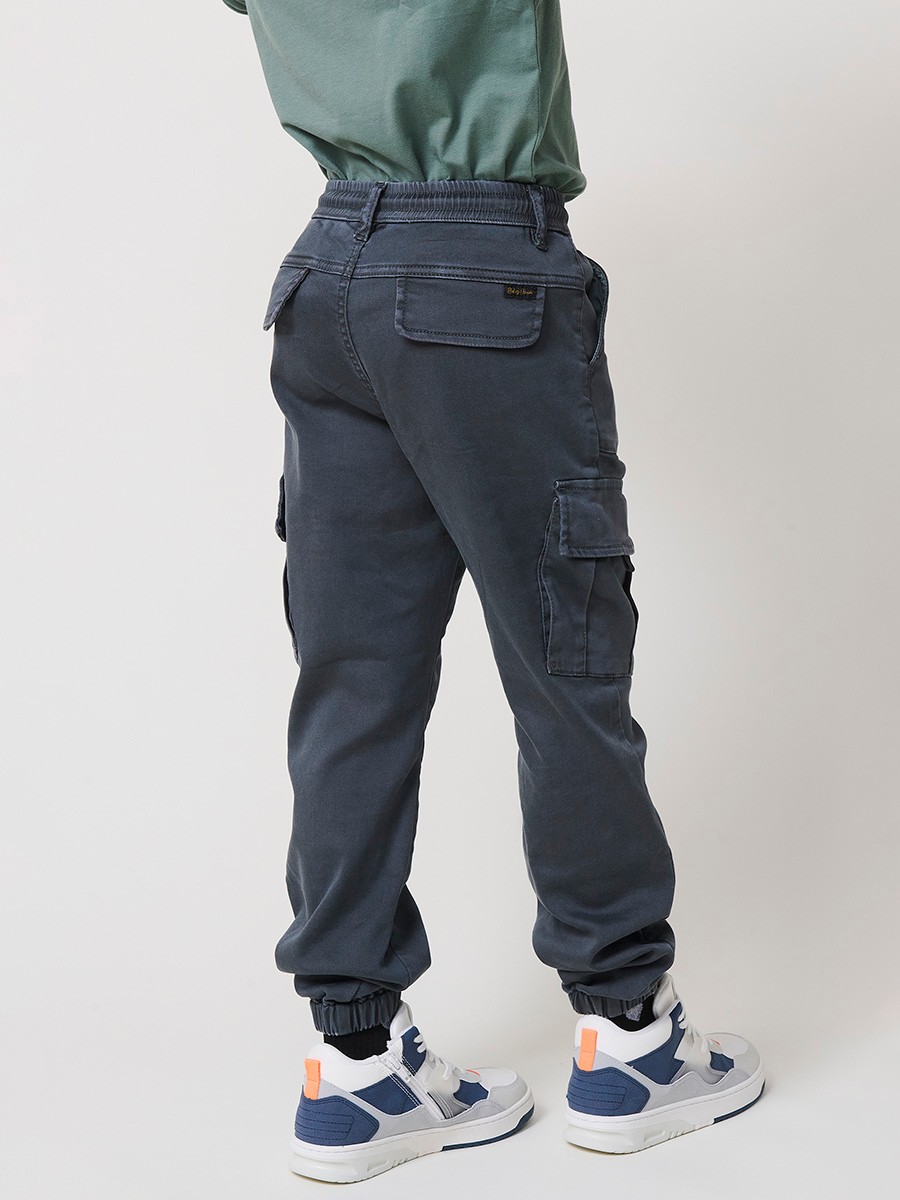 Pantalón jogger de niño en knit denim elástico color verde con bolsillos cargo. 100% algodón, cómodo y moderno.