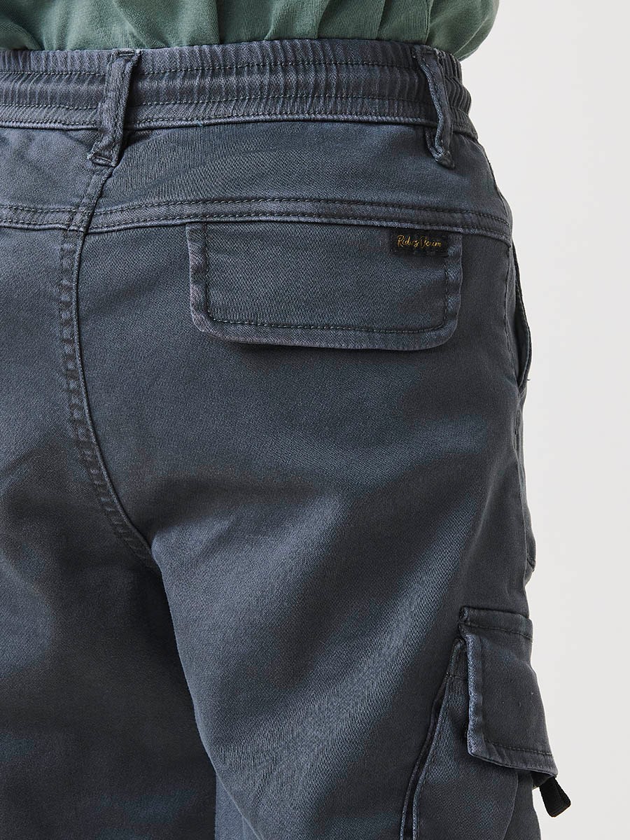Pantalón jogger de niño en knit denim elástico color verde con bolsillos cargo. 100% algodón, cómodo y moderno.