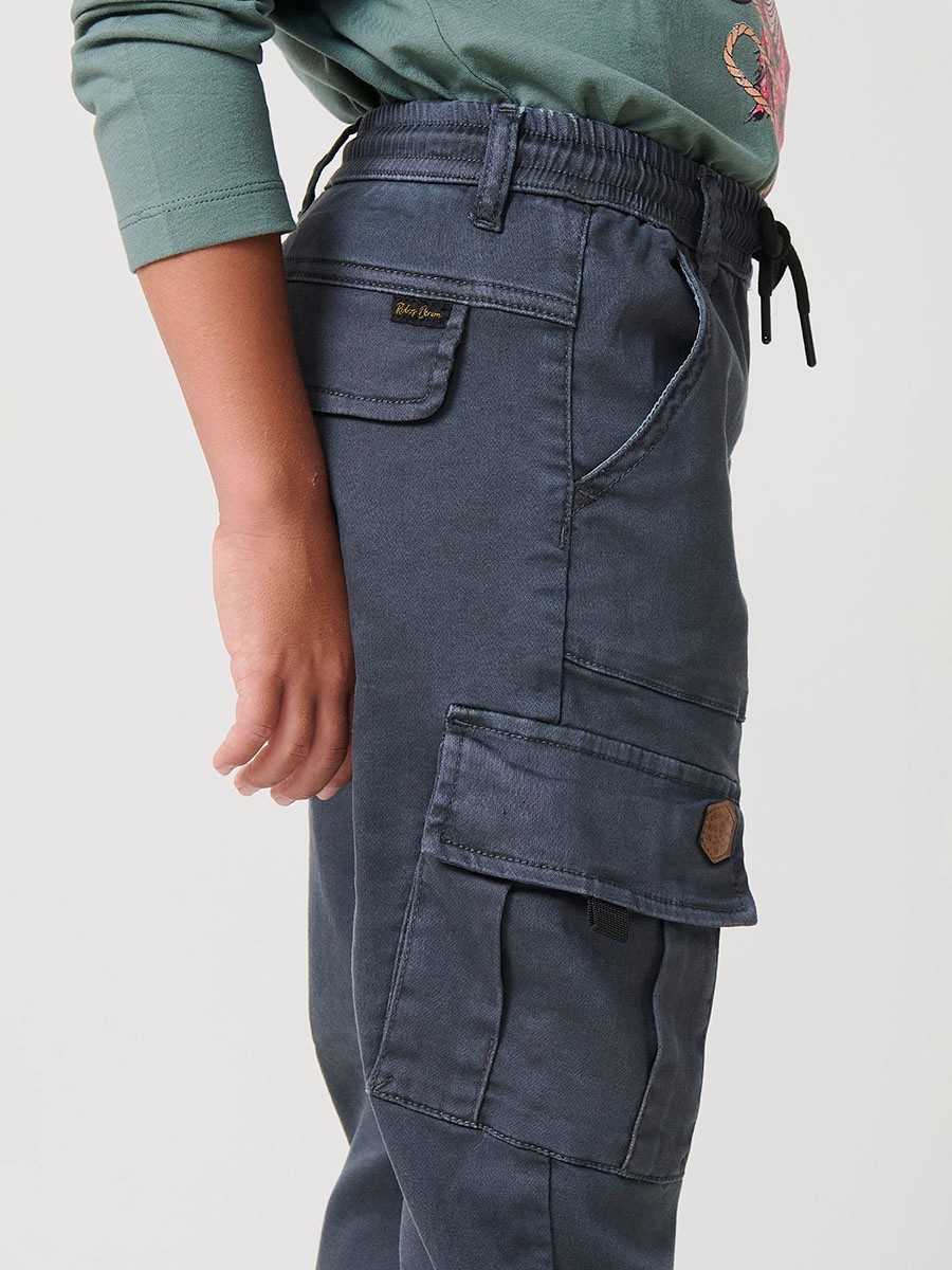 Pantalón jogger de niño en knit denim elástico color verde con bolsillos cargo. 100% algodón, cómodo y moderno.