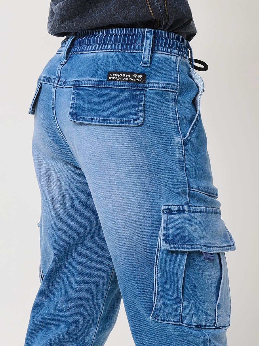 Pantalón jogger de niño en knit denim elástico color azul medio efecto lavado con bolsillos cargo. 100% algodón, cómodo y moderno.