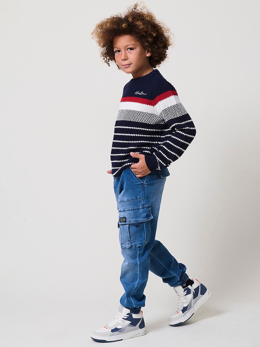 Jersey de niño en punto de algodón color navy con rayas crudo y rojas, cuello redondo y puños acanalados.
