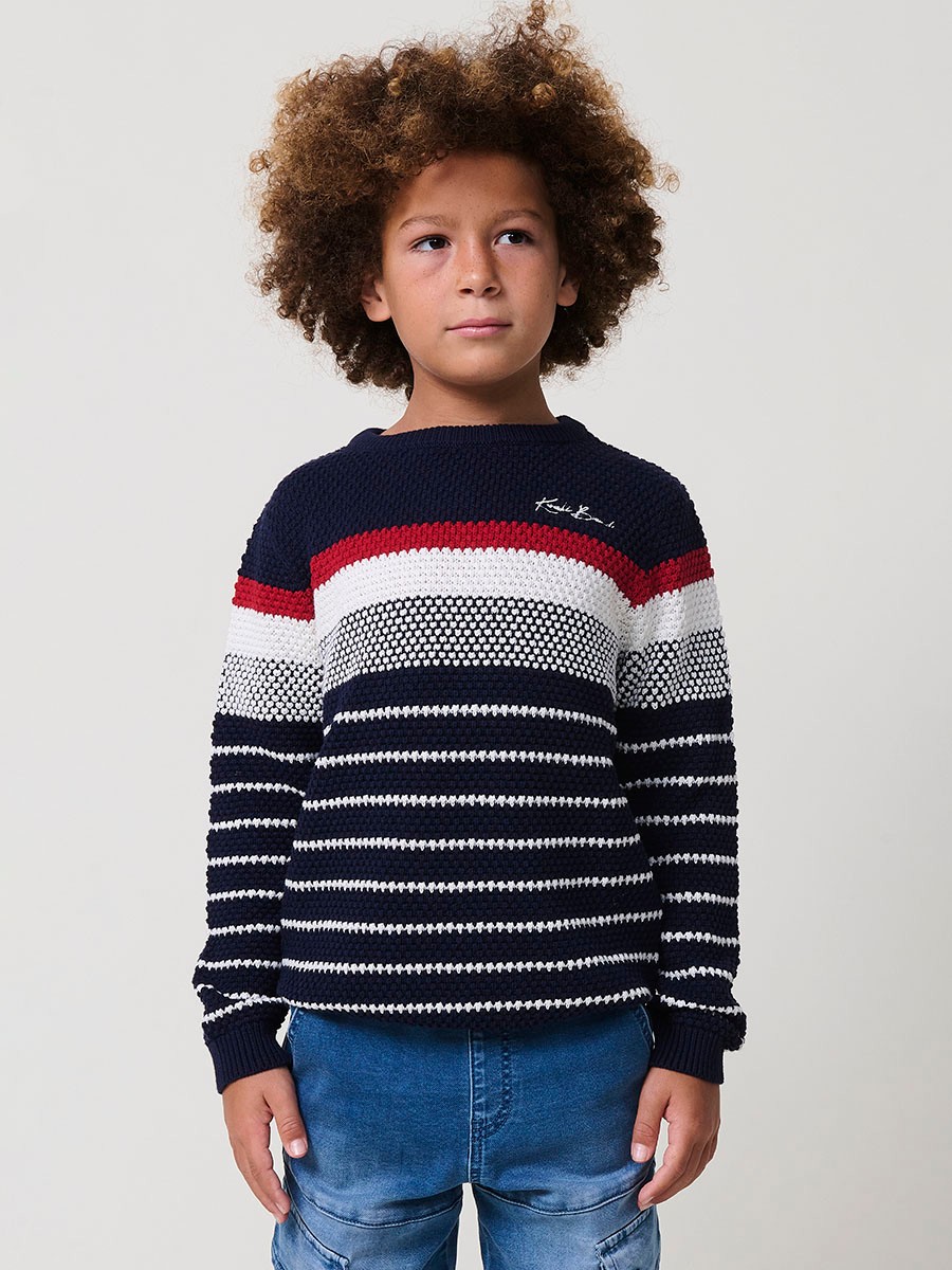 Jersey de niño en punto de algodón color navy con rayas crudo y rojas, cuello redondo y puños acanalados.