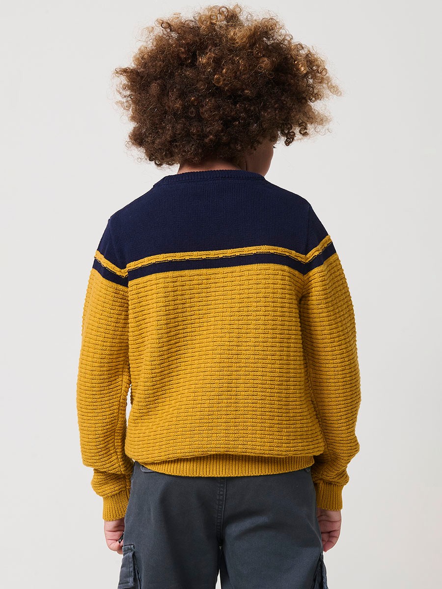 Jersey de niño en punto fantasía de algodón color mostaza con franja superior, cuello redondo y puños de canalé.
