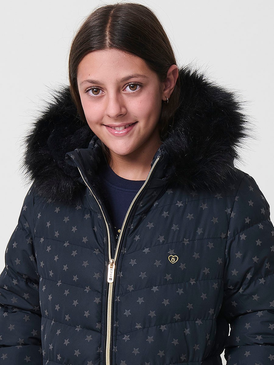 Chaqueta acolchada de niña en color navy con estampado de estrellas flocadas, cuello alto, capucha desmontable con pelo sintético y puños de canalé.
