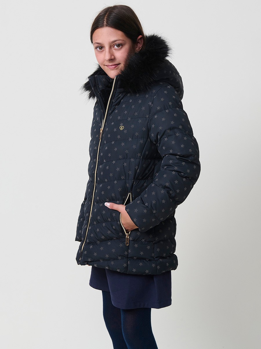 Chaqueta acolchada de niña en color navy con estampado de estrellas flocadas, cuello alto, capucha desmontable con pelo sintético y puños de canalé.
