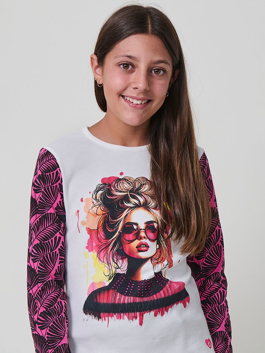 Camiseta de niña en algodón elástico con cuerpo de canalé blanco, estampado de chica con gafas de sol y mangas estampadas en fucsia y negro.